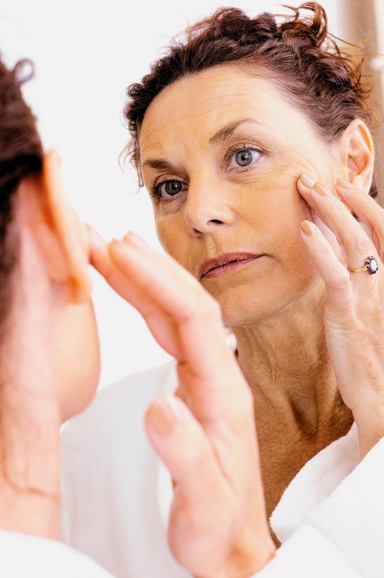Woman examining her skin in the mirror